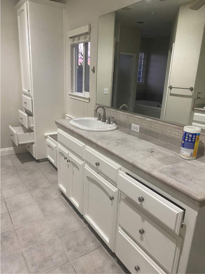 A beautifully refinished set of bathroom cabinets after a professional painting service. The cabinets now feature a fresh, smooth coat of high-quality paint, enhancing their modern and elegant look. The new finish brightens the bathroom, providing a clean, stylish, and durable update. The crisp, flawless paint application ensures long-lasting protection against moisture while seamlessly blending with the bathroom’s decor.