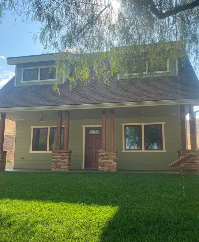 A residential home exterior before painting, showing faded, weathered paint with visible wear and discoloration. The walls appear dull, with peeling and chipping paint in certain areas, giving the home an aged and neglected appearance. The trim and siding lack vibrancy, highlighting the need for a professional exterior painting service to restore curb appeal and protect the home's surface from the elements.