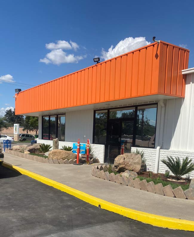 A freshly painted commercial storefront after a professional painting service, featuring a bold, vibrant color that enhances visibility and attracts customers. The clean, even finish on the exterior walls gives the business a polished and professional look. Crisp trim and accents add contrast, making signage stand out. This transformation not only improves curb appeal but also reinforces the store’s branding and professionalism.