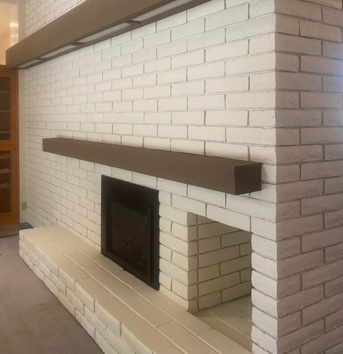 A beautifully painted indoor brick chimney after a professional painting service. The fresh coat of paint enhances the texture and character of the bricks, giving the fireplace a modern, polished look that complements the interior design. The even, high-quality finish provides a clean and updated aesthetic, transforming the chimney into a stylish focal point within the living space.
