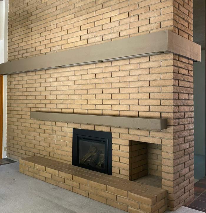 An indoor brick chimney before professional painting, showing aged and discolored bricks with uneven tones. The surface appears worn, with soot stains and minor cracks affecting its aesthetic appeal. The outdated look contrasts with the surrounding interior, making the space feel less refined. This image highlights the need for a professional painting service to refresh and modernize the chimney while preserving its structural integrity.