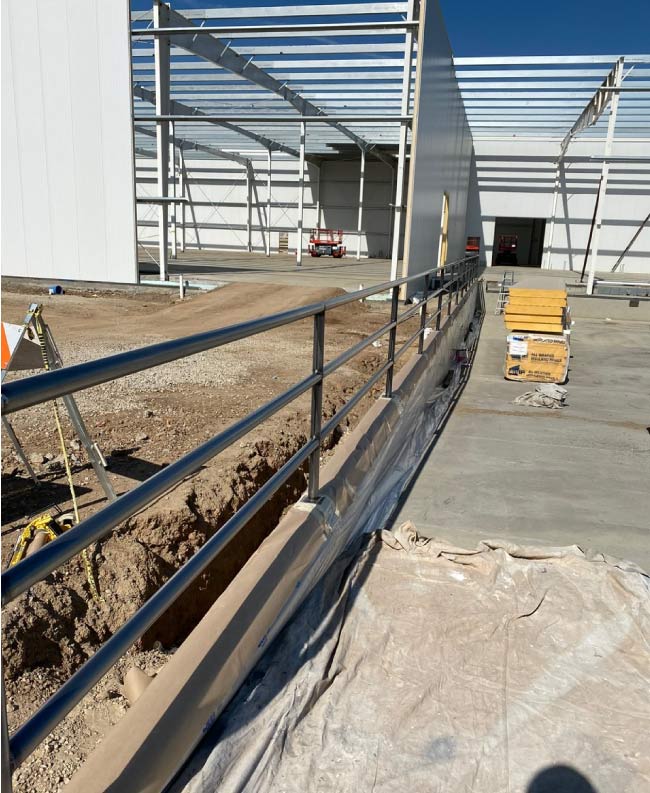 A commercial building under construction before painting, featuring unfinished drywall and exposed surfaces. The raw walls and ceilings lack color and protection, giving the space an incomplete and industrial look. Construction dust and uneven textures highlight the need for a professional painting service to provide a smooth, durable finish that will complete the building’s transformation into a functional workspace.