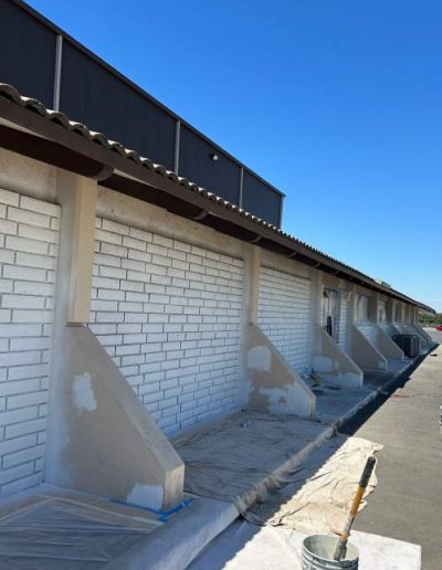 Faded and weathered commercial building exterior with peeling paint and discoloration