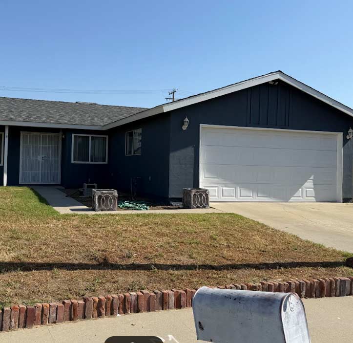 A beautifully renovated two-story home in Visalia featuring a fresh coat of warm beige paint and crisp white trim, enhancing its curb appeal.