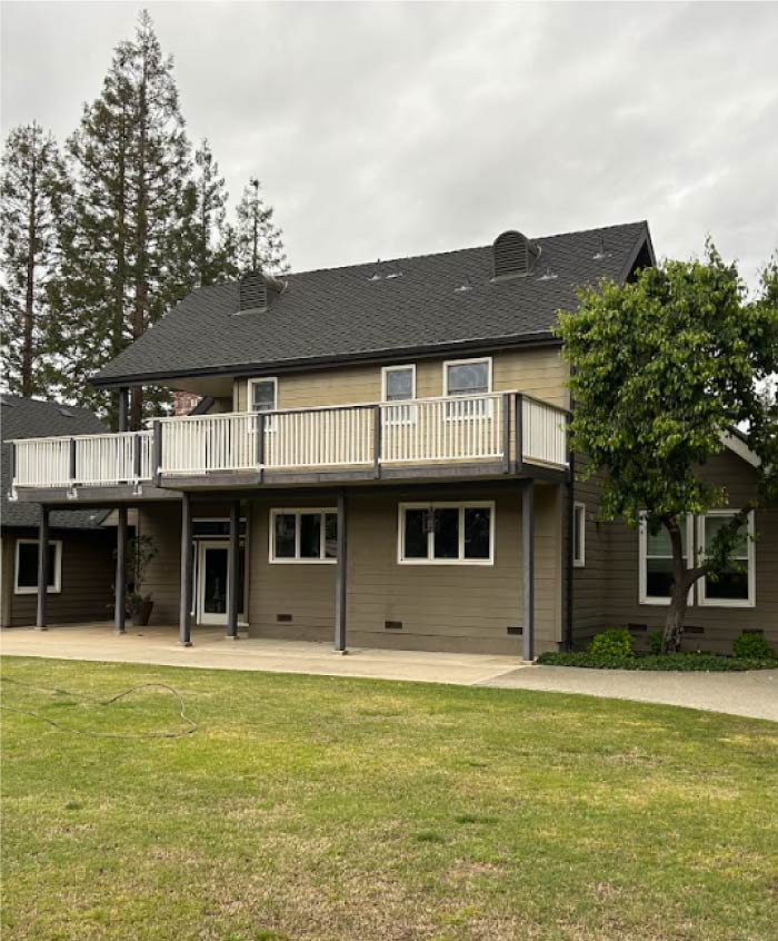 A modern home with a striking dark gray exterior paint job, complemented by contrasting light-colored accents, exemplifying contemporary design.